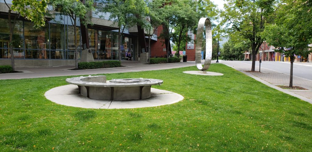 A city lawn with two metal sculptures